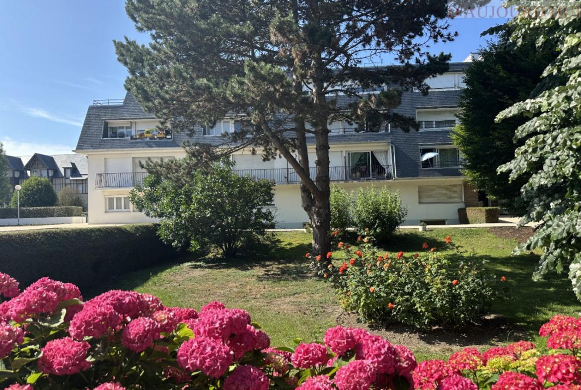 Appartement 2 pièces de 56 m² à Deauville avec balcon au calme, vue sur jardin, cuisine indépendante, salle d’eau moderne, cave et parking souterrain.
