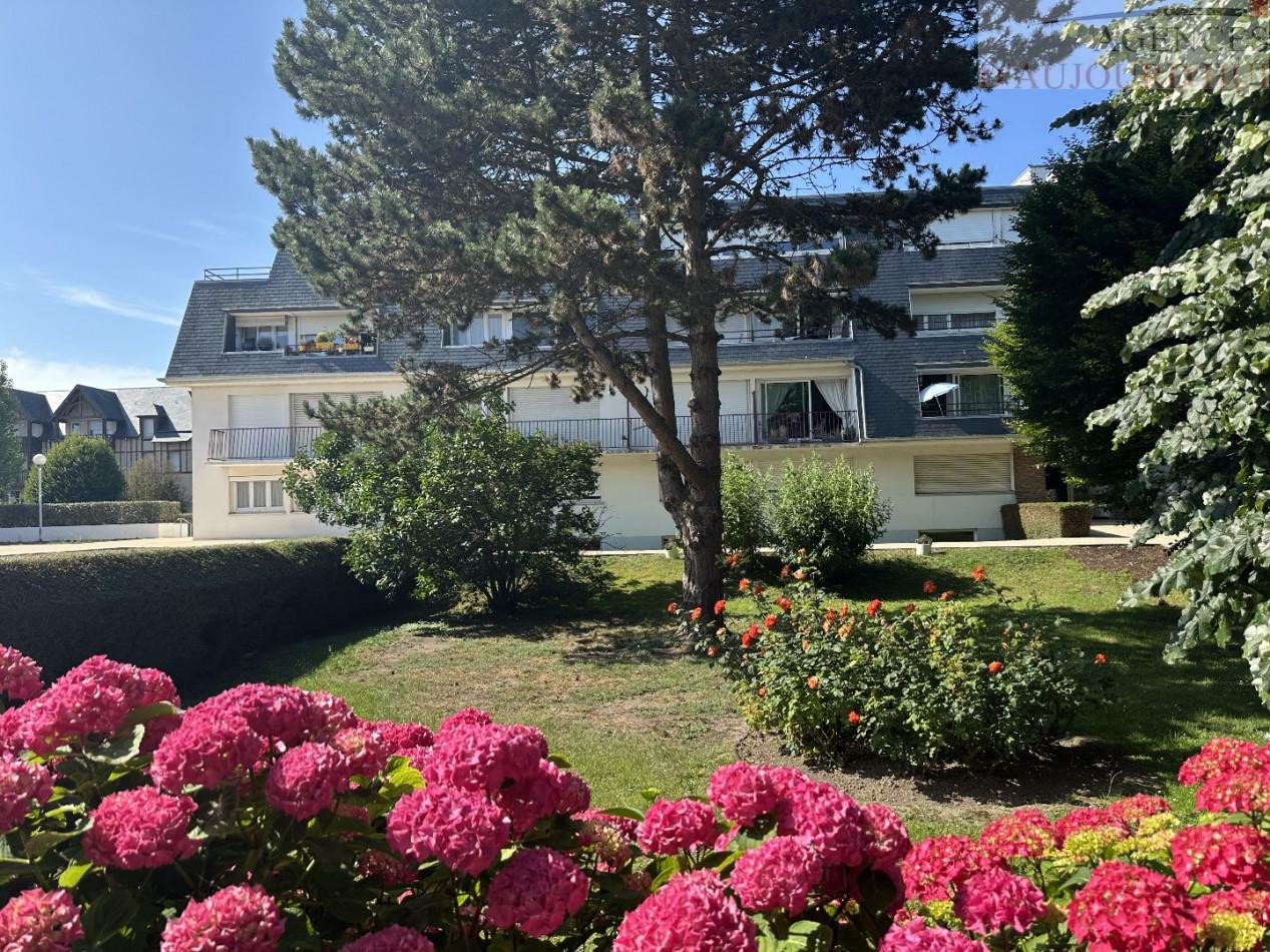 Appartement 2 pièces de 56 m² à Deauville avec balcon au calme, vue sur jardin, cuisine indépendante, salle d’eau moderne, cave et parking souterrain.