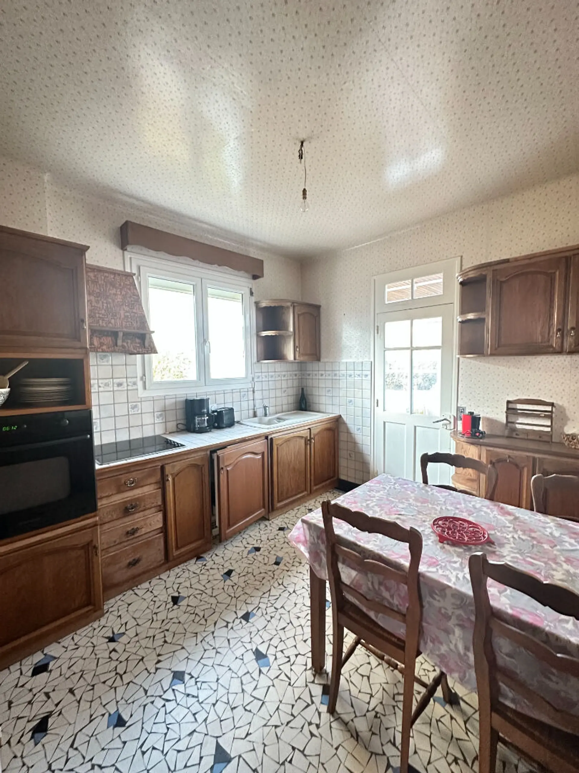 Maison 5 pièces de 98 m² à Saint‑Brieuc, terrain de 318 m², garage, séjour parqueté, véranda exposition Sud-Ouest, possibilité d’aménagement à l’étage.