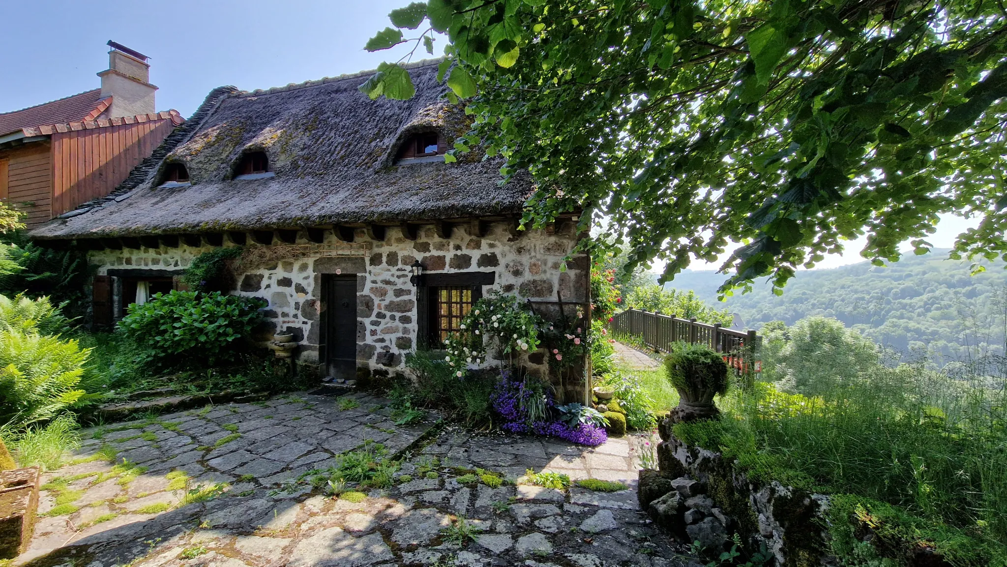 Maison en pierre avec toit de chaume et vue imprenable sur la vallée de la Jordanne