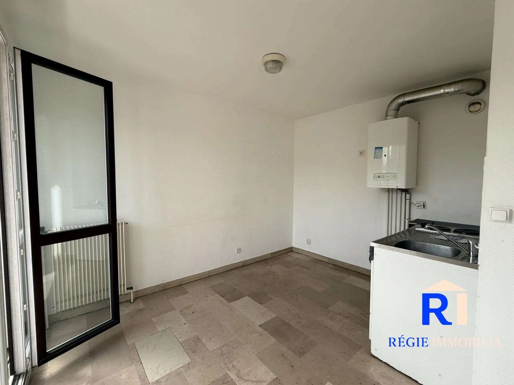 Cuisine simple et ouverte sur la pièce à vivre Appartement T2 lumineux avec balcon et parking à Échirolles La Frange Verte 