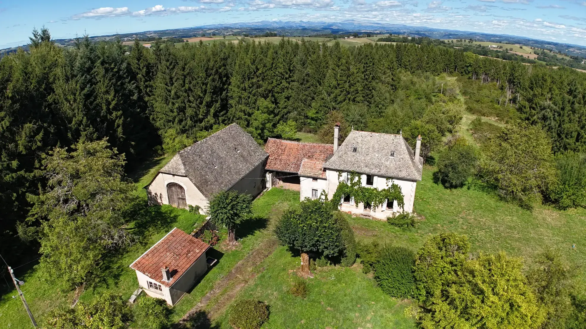 Maison en pierre à rénover avec dépendances sur un domaine boisé de 7,5 hectares à Montsalvy 